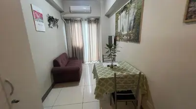 a living room with a table and a chair at Coast Residence Sea View Balcony Netflix WiFi Near MOA 3146 in Manila