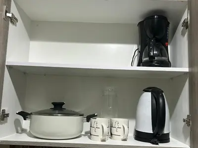 a shelf with pots and pans and a tea kettle at 2BR Coast Residences in Manila