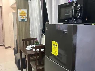 a kitchen with a small table and a refrigerator at 2BR Coast Residences in Manila