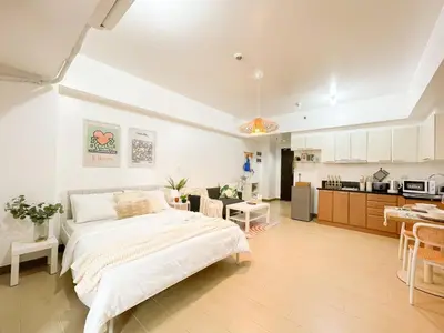 a bedroom with a large bed and a kitchen at Cozy Condo in Venice BGC with balcony #vlrtc28C in Manila