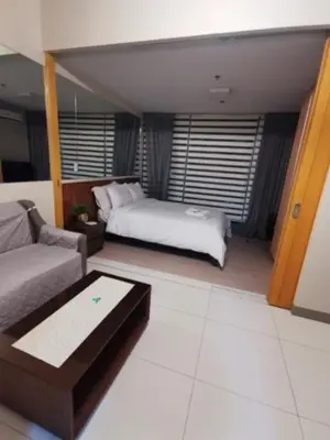 a living room with a bed and a couch at One Uptown Residence in Manila