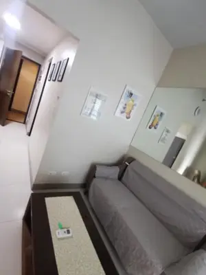 a small living room with a couch in a room at One Uptown Residence in Manila