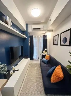 a living room with a couch and a tv at The W Place in Manila