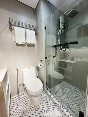 a bathroom with a toilet and a glass shower at The W Place in Manila