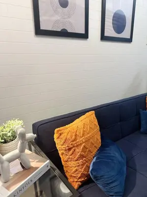 a blue couch with a yellow pillow on it at The W Place in Manila