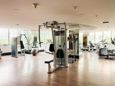 a gym with treadmills and machines in a room at Best Staycation in BGC Central #aatft13j in Manila