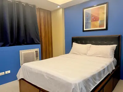 a bed in a room with a blue wall at 7H Kiel Hotel NAIA Terminal 3 in Manila