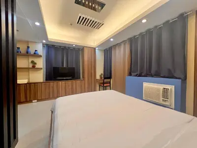 a bedroom with a white bed and a television at 7H Kiel Hotel NAIA Terminal 3 in Manila