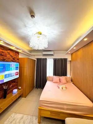 a bedroom with a bed and a flat screen tv at European Inspired Shore 2 Residences in Manila