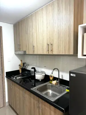 a kitchen with a sink and wooden cabinets at European Inspired Shore 2 Residences in Manila