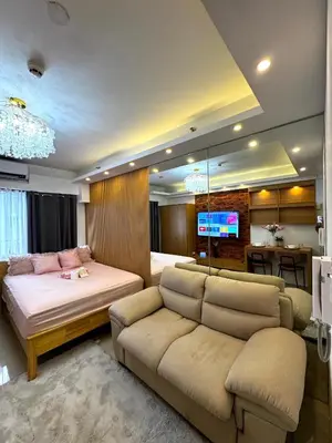 a bedroom with a bed and a couch and a tv at European Inspired Shore 2 Residences in Manila