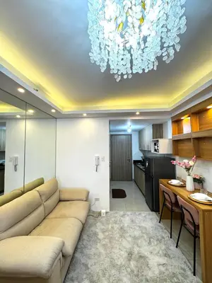 a living room with a couch and a chandelier at European Inspired Shore 2 Residences in Manila