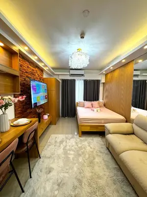 a living room with a bed and a desk at European Inspired Shore 2 Residences in Manila