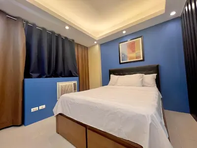 a bedroom with a blue wall and a bed at 5Q Place Hotel Manila Airport in Manila