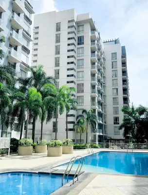 a swimming pool in front of a large apartment building at 5Q Place Hotel Manila Airport in Manila