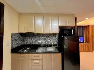 a kitchen with a sink and a black refrigerator at 5Q Place Hotel Manila Airport in Manila