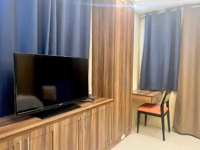 a flat screen tv sitting on top of a wooden entertainment center at 5Q Place Hotel Manila Airport in Manila