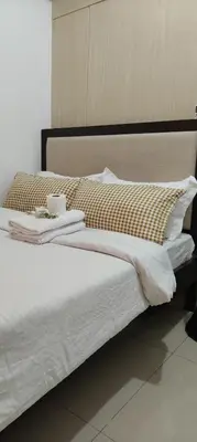 a bed with white sheets and pillows on it at Jazz Apartment Unit in Manila