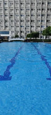 a large swimming pool in front of a large building at Jazz Apartment Unit in Manila