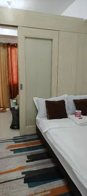 a bedroom with a large bed with a headboard at Jazz Apartment Unit in Manila