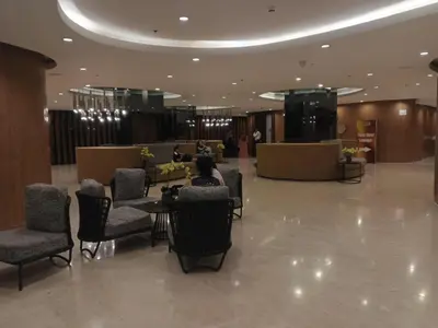 a person sitting at a table in a lobby at Shore 2 Residences Mall of Asia staycation in Manila
