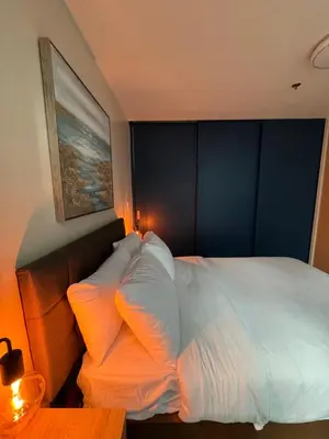 a bedroom with a large white bed with orange pillows at Rustic Elegance New One Bedroom One Uptown Free parking in Manila