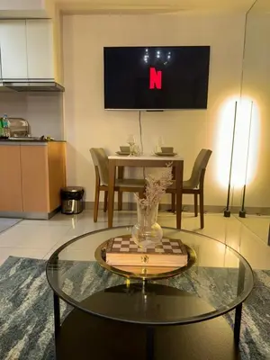 a living room with a table and a tv on the wall at Rustic Elegance New One Bedroom One Uptown Free parking in Manila