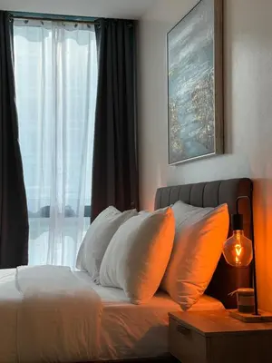 a bedroom with a bed with white pillows and a window at Rustic Elegance New One Bedroom One Uptown Free parking in Manila