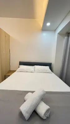 a bedroom with a bed with two towels on the floor at Cozy Condo Beacon Tower Makati in Manila