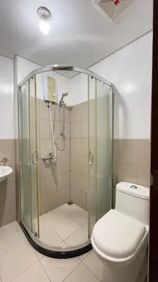 a bathroom with a shower with a toilet and a sink at Cozy Condo Beacon Tower Makati in Manila