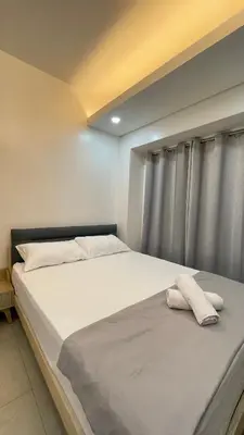 a bed with two pillows on it in a room at Cozy Condo Beacon Tower Makati in Manila