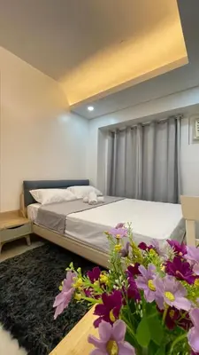 a bedroom with a bed with flowers on the floor at Cozy Condo Beacon Tower Makati in Manila