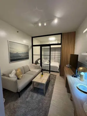 a living room with a couch and a bed at Heathers Crib In Ayala Makati City in Manila