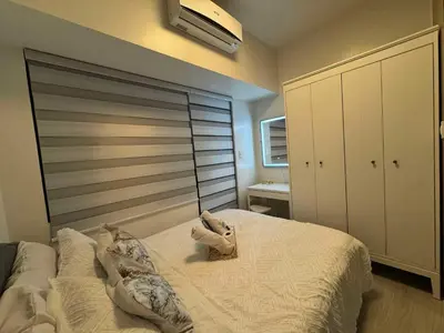 a bedroom with a large bed with pillows on it at Heathers Crib In Ayala Makati City in Manila