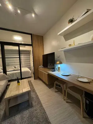 a living room with a desk and a bed at Heathers Crib In Ayala Makati City in Manila