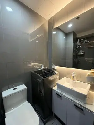 a bathroom with a toilet and a sink and a stove at Heathers Crib In Ayala Makati City in Manila