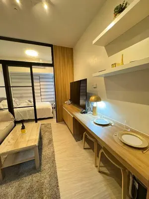 a room with a desk with a television and a bed at Heathers Crib In Ayala Makati City in Manila