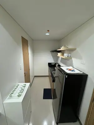 a small kitchen with a black and white stove at Bloom Residences by Casa Stellar in Manila