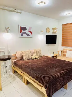 a bedroom with a large bed and a flat screen tv at Fablo Getaway beside EK in Santa Rosa