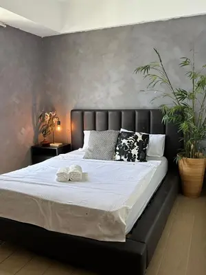 a bed with two towels on it in a bedroom at Relaxing Suite Across NAIA Terminal 3 in Manila