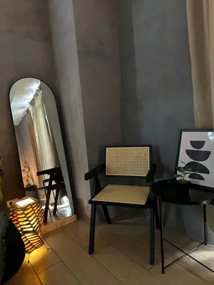 a room with a chair and a table and a mirror at Relaxing Suite Across NAIA Terminal 3 in Manila
