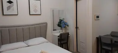 a bedroom with a bed and a table and a chair at 150 Newport Blvd Condotel near T3 by Alps in Manila