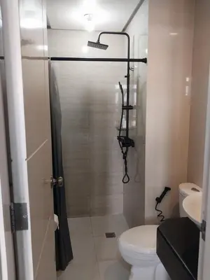 a bathroom with a shower with a toilet and a sink at 150 Newport Blvd Condotel near T3 by Alps in Manila