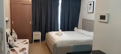 a small room with two beds and a chair at 150 Newport Blvd Condotel near T3 by Alps in Manila