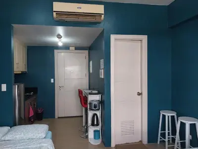 a living room with blue walls and a white door at 150 Newport Blvd Condotel near T3 by Alps in Manila