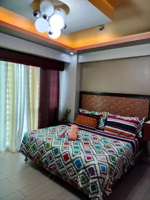 a bedroom with a bed with a colorful comforter at ROOM NEAR AIRPORT BY RQUi in Manila