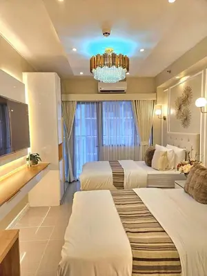 a hotel room with two beds and a chandelier at Jay Suite in Manila