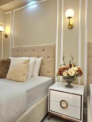 a bedroom with a bed with a vase of flowers on a table at Jay Suite in Manila
