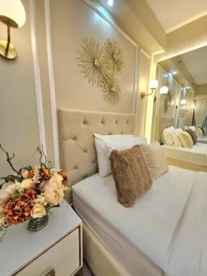 a small bedroom with a bed and a mirror at Jay Suite in Manila