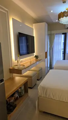 a hotel room with a bed and a flat screen tv at Jay Suite in Manila